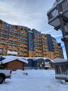 een groot appartementencomplex met sneeuw op de grond bij Central Val Thorens - 4 pers - Newly renovated in Val Thorens +10 foto's