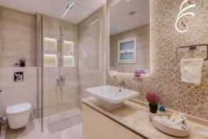 a bathroom with a sink and a glass shower at Luxurious 3Bd Hotel Apt in compound Sheikh Zayed with Pool and Gym access in Sheikh Zayed +59 photos