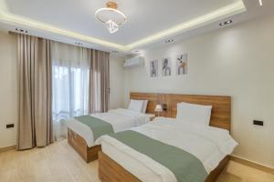 a hotel room with two beds and a window at Luxurious 3Bd Hotel Apt in compound Sheikh Zayed with Pool and Gym access in Sheikh Zayed
