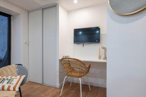 a room with a chair and a tv on a wall at Studio de Luxe Entièrement Neuf - Proche Paris in Gagny +5 photos