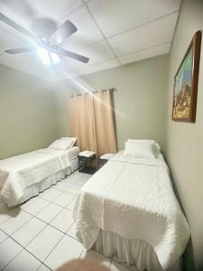 Habitación León Queen Deluxe في ليون: غرفة نوم بها سريرين ومروحة سقف +9 صور