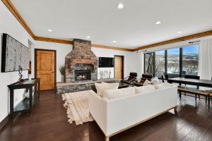 a living room with a white couch and a fireplace at Wild Horse Meadows Eden Powder Mtn in Wolf Star