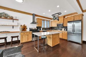 a kitchen with wooden cabinets and a stainless steel refrigerator at Wild Horse Meadows Eden Powder Mtn in Wolf Star +51 photos