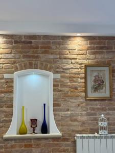 a shelf with vases on a brick wall at Ca' Dolce Rosa in Burano