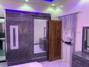 Keur MAME TAWFEKH في Thies: غرفة بباب زجاجي منزلق وتلفزيون