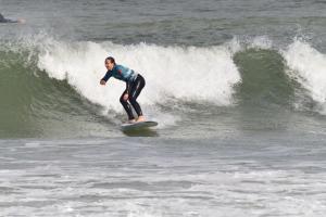 Un uomo che cavalca un'onda su una tavola da surf nell'oceano di GO4SURF beach Lofts a Peniche