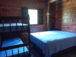 2 stapelbedden in een kamer met een bakstenen muur bij Chácara Rancho do Lago in Socorro +33 foto's