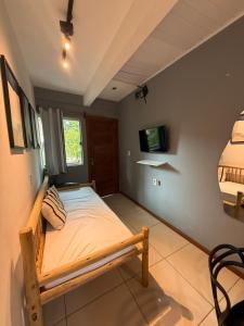 ein Schlafzimmer mit einem Bett und einem Fernseher an der Wand in der Unterkunft Pituba Ville - Ap - 1 andar - 2/4 in Itacaré