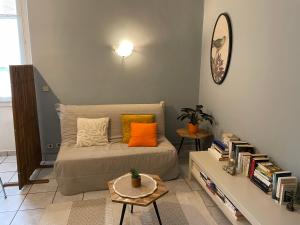 ein Schlafzimmer mit einem Bett mit orangefarbenen Kissen und einem Tisch in der Unterkunft Le Mont Joly & Les 4 Têtes in Sallanches