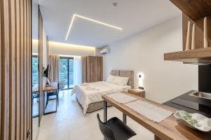 World Luxury Suites Trikala في تريكالا: غرفه فندقيه بسرير ومكتب ومطبخ