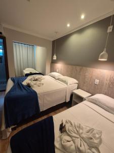 a hotel room with two beds with blue sheets at Pousada Vale do Chapéu in Capitólio