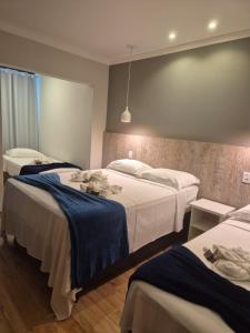 a bedroom with two beds with blue sheets at Pousada Vale do Chapéu in Capitólio +66 photos