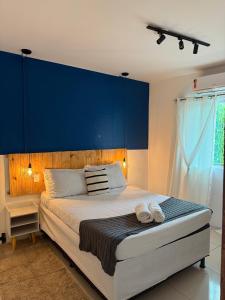 ein Schlafzimmer mit einem großen Bett mit blauem Kopfteil in der Unterkunft Pituba Ville - Ap - 1 andar - 2/4 in Itacaré