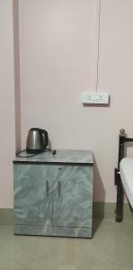 a silver cabinet with a tea kettle on top of it at Backpackers' Haven in Guwahati