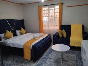 a bedroom with a bed and a couch and a table at Bliss BnB in Nairobi
