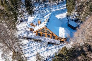 Eine Draufsicht auf ein Haus im Schnee in der Unterkunft Chalet Mazama - Private Lake - Hot Tub - 16P in Wentworth-Nord