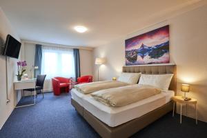 Una habitación de hotel con una cama grande y un escritorio. en Hotel Ambassador, en Solothurn 46 fotos más