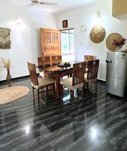 a dining room with a table and chairs and a refrigerator at Casa Palolem in Canacona +3 photos