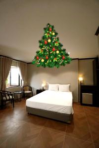 Un dormitorio con un árbol de Navidad colgando encima de una cama. en HY Local Budget Hotel - 5 mins walk to Hoi An Ancient Town, en Hoi An