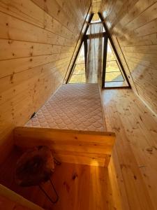 Sunset Cottage Busheti : سرير في غرفة خشبية مع نافذة