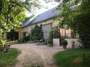 un granero con una entrada de grava delante de él en Chez Valérie et François, en Moux-en-Morvan