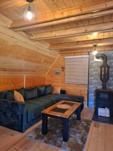 a living room with a couch and a table at Evergreen cabins Golija in Golija