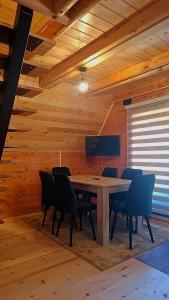 a wooden dining room with a table and chairs at Evergreen cabins Golija in Golija
