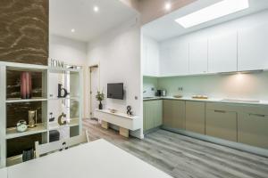 Una cocina con gabinetes blancos y un televisor. en Apartamento en excelente ubicación, centro de Barcelona, en Barcelona 14 fotos más