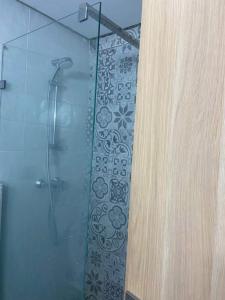 a bathroom with a shower with a glass door at Apartment kamal park in Mohammedia