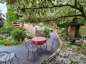 Un patio con mesa y sillas y un cenador. en Maison proche de la gare, en Lisieux