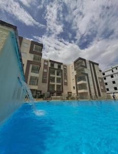 a pool with a fountain in front of some buildings at Apartment222 2 rooms Al Bousten Hammamet in Hammamet Sud