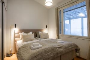 a bedroom with a large bed with two towels on it at White Elegant Suite by the River in Rovaniemi
