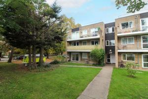 an apartment building with a lawn in front of it at Neat 2 bedroom ground floor flat in Beckenham