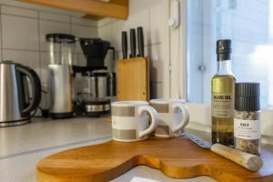 a bottle of wine and two cups on a cutting board at White Elegant Suite by the River in Rovaniemi