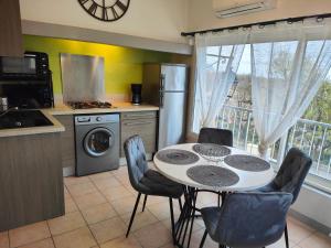 una cucina con tavolo e sedie in una cucina di Appartement vue sur le lac ad Aiguines