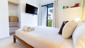 een slaapkamer met een bed en een tv aan de muur bij Villa Castillo in Higuey