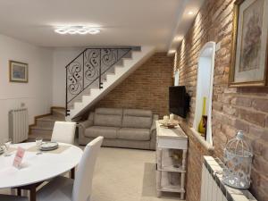 a living room with a dining table and a staircase at Ca' Dolce Rosa in Burano