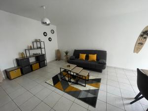 a living room with a couch and a table at À deux pas de la mer in Marennes