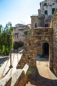 un muro di mattoni con arco di fronte a un edificio di La casa di Marge a Sanremo