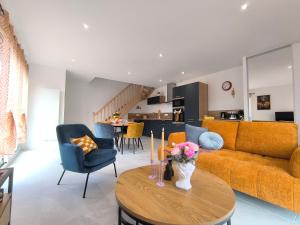 L'Art Pop - Chic & Coloré Plage à 5 min en voiture في Biville-sur-Mer: غرفة معيشة بها أريكة وطاولة