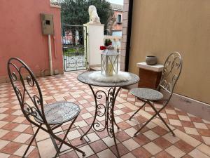 a table with two chairs and a lantern on a patio at Ca' Dolce Rosa in Burano