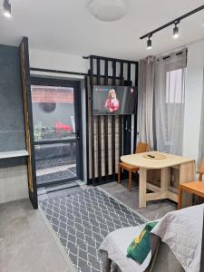 a living room with a tv and a table at Mieszkanie 3 pokoje-Faktura in Szczecinek