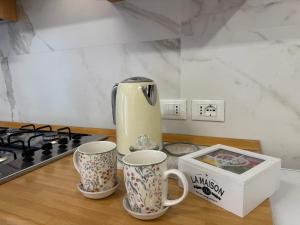 two coffee mugs sitting on a counter next to a stove at Ca' Dolce Rosa in Burano