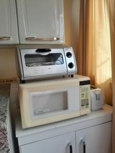 a microwave sitting on top of a cabinet at Recanto aconchegante próximo ao mar in Vila Velha