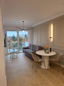 a living room with a couch and a table at Let's Sea SPA - Premium Apartamenty z ogródkiem, przyjazne zwierzętom in Gąski +37 photos