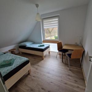 a room with two beds and a desk and a window at Ferienwohnung Sunny 2 in Mittenwalde