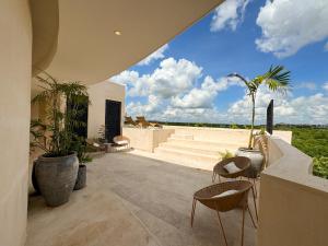un patio con due sedie e piante di Oniric Condo Tulum a Tulum