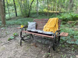 eine Parkbank mit einer Decke und Kissen darauf in der Unterkunft Creekwood Cottage in Peru + 4 Fotos
