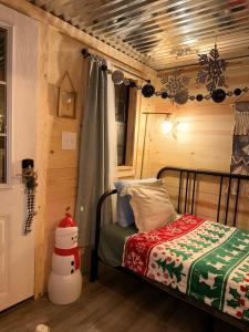 ein kleines Schlafzimmer mit einem Bett und einem Schneemann an der Wand in der Unterkunft Creekwood Cottage in Peru