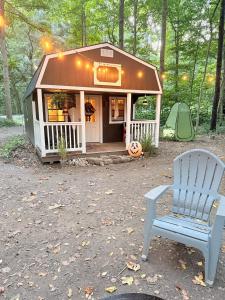ein kleines Gebäude mit einem Stuhl und einem Zelt in der Unterkunft Creekwood Cottage in Peru